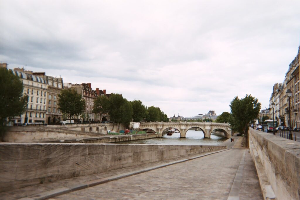 View of the River Seine in Paris, stone walkway along side of river. Wander&Prosper.